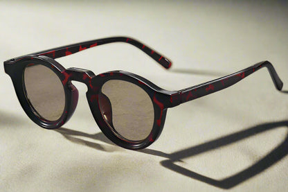 Sunglasses with tortoiseshell frame on a gray surface