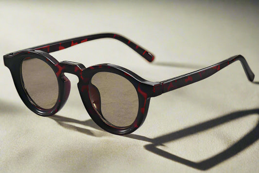 Sunglasses with tortoiseshell frame on a gray surface